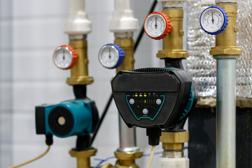 A circulation pump with thermometers is installed in a heating or water supply system