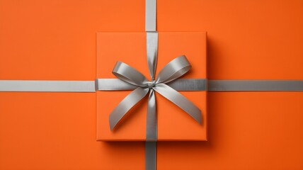 Minimalist square gift box with silver satin ribbon on vibrant orange background top view, elegant present for celebration or surprise