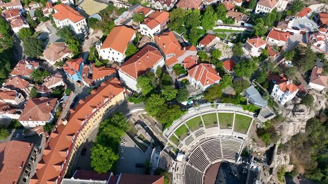 Plovdiv aerial drone view highlighting Ancient Roman Theatre, red roof houses, historic city Bulgaria, amphitheater cultural landmark. The central post office and neighbourhoods of Philippopolis