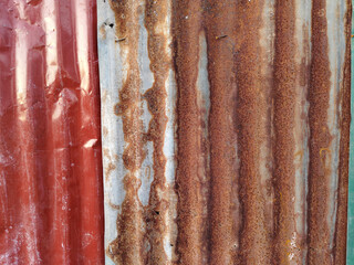 Old and rusty zinc sheet wall. Vintage style metal sheet roof and fence texture. Pattern of old metal sheet. Rusting metal or siding. Corrosion of galvanized. Background and texture in retro concept.