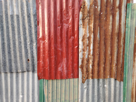 Old and rusty zinc sheet wall. Vintage style metal sheet roof and fence texture. Pattern of old metal sheet. Rusting metal or siding. Corrosion of galvanized. Background and texture in retro concept.