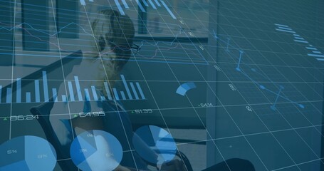 Using tablet, businesswoman in blazer studying charts at office with swivel chair and blinds