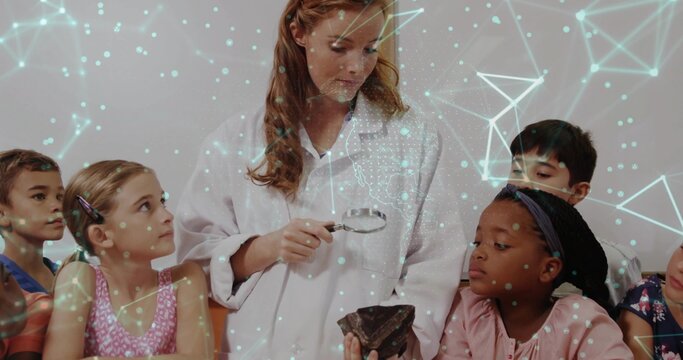 Examining teacher in white lab-coat holding lens at school inspecting rock with AR network overlay