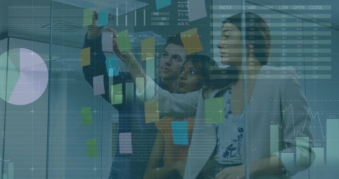 Planning team placing sticky notes on office glass partition in business attire, data overlays