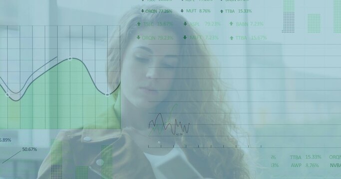 Holding tablet, professional woman wearing light coat presenting data in office with charts