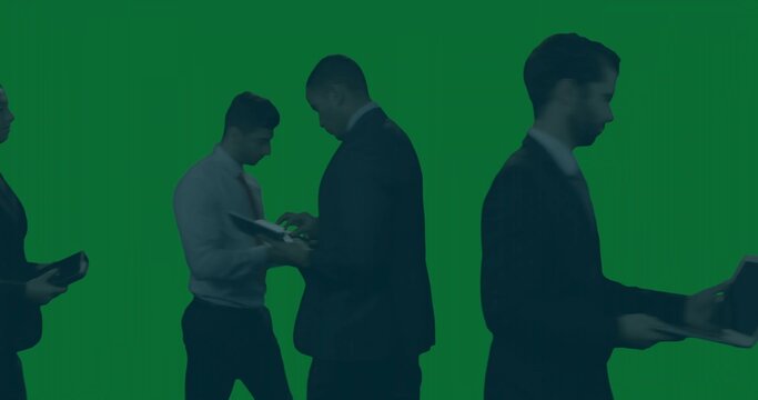 Meeting business group checking files and tablets at green chroma backdrop in suits holding laptop - Powered by Adobe