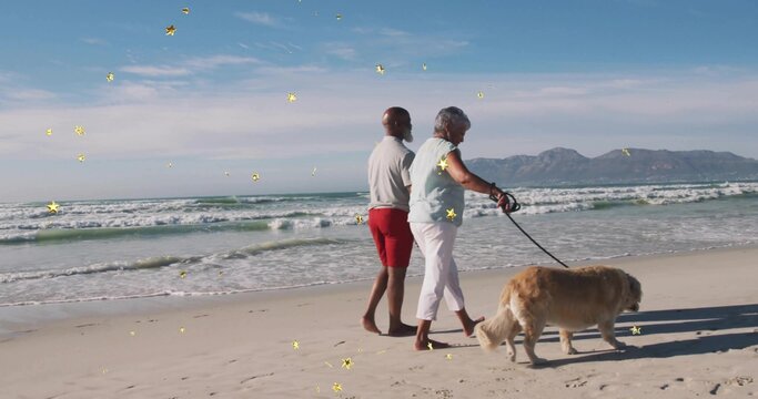 Walking mature couple in light clothes along sandy beach at shore, with golden retriever on leash - Powered by Adobe