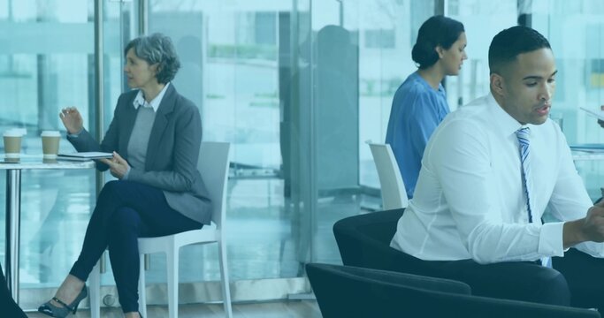Checking businessman in white shirt, striped-tie scrolling phone in office lobby, with takeout cups