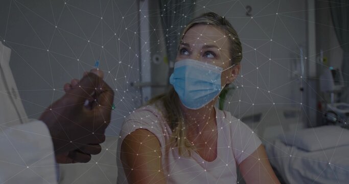 Looking up, patient wearing pink shirt, blue mask on hospital bed with doctor hand, network overlay - Powered by Adobe