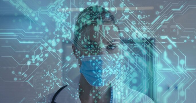 Standing clinician wearing lab coat, stethoscope, facing corridor with cyan hologram and blue mask