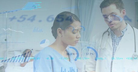 Reviewing labcoat doctor and light-blue scrub nurse studying overlays in ward with stethoscope
