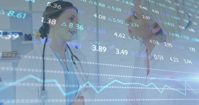 Discussing two female doctors reviewing in clinic, wearing lab coats, stethoscope, overlaid data - Powered by Adobe