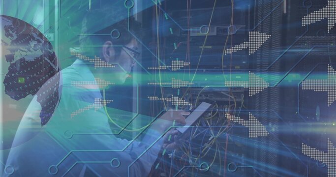 Working Korean technician adjusting cables at server racks, holding tablet in white shirt, glasses