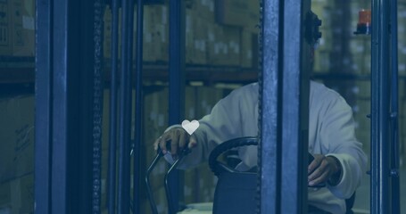 Operating forklift, male steering controls in warehouse aisle with heart overlay, wearing light top