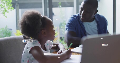 Writing girl doing homework at home with adult assisting, green pencil, laptop, floating UI labels