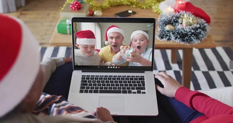 Showing laptop screen with three on call wearing Santa hats at home, striped top mouse nearby