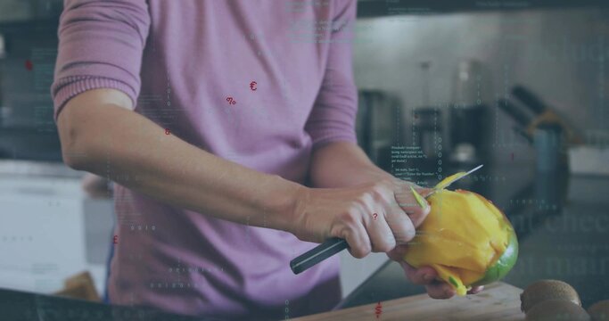 Peeling hands in purple top stripping yellow mango skin on kitchen cutting board with paring knife