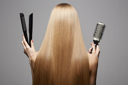 beautiful blond hair woman holding styling accessories. Back of girl with Healthy hair