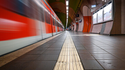 Subway station with moving train in Germany.