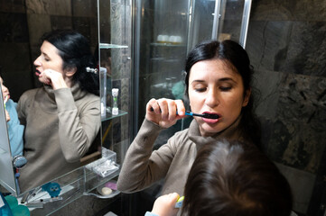 Morning routine a mirror reflection of mother and child brushing teeth in harmony at home bathroom, sharing a precious moment of dental care and family bonding