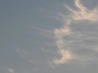 Soft pastel cirrus clouds forming delicate flowing patterns at sunset