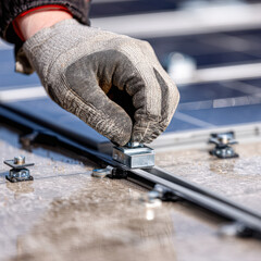 A person in a glove is installing a component onto a solar panel, showcasing renewable energy technology in action.
