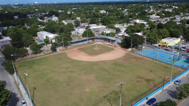Drone 4K UHD medium hight aerial view of a public baseball field and surrounding city, highlighting wellness and everyday identity.