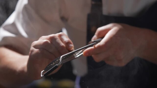 A person is cooking and using a strainer to sift flour. The scene is set in a kitchen with a stove and a bowl. The person appears to be focused on the task at hand