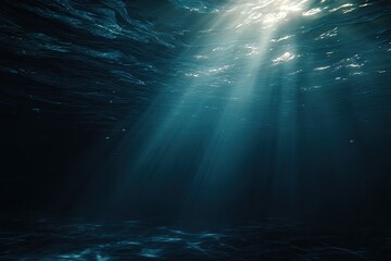 Sunbeams pierce deep, dark blue ocean water from above