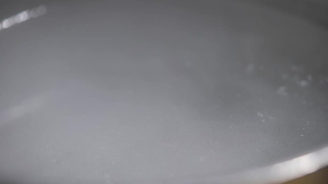 A pan of water is boiling on a stove. The steam rising from the pan creates a sense of warmth and comfort