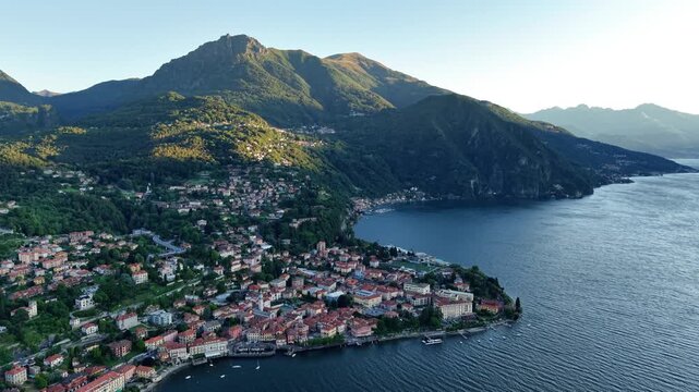 colorful town overlooking shimmering bay, brightly lit settlement nestled beneath soaring mountain peaks
