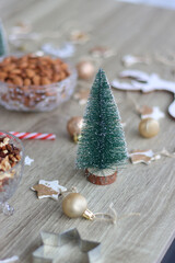 Various Christmas decorations, cookies, chocolate and nuts on wooden background. Selective focus.