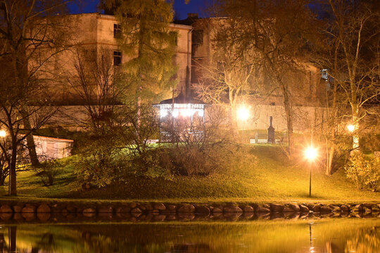 colorful and bright autumn landscape from the city park in dark autumn, illuminated pond with charming reflections in the water, Cesis, Latvia - Powered by Adobe