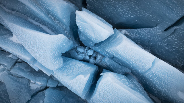 Aerial view of jagged ice formations, their crystalline surfaces catching the light in a dance of blues and whites, Jokulsarlon, Sveitarfelagid Hornafjordur, Iceland.