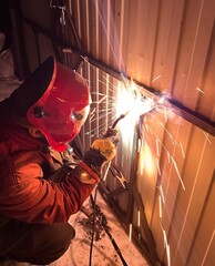 A male welder welds metal. Sparks, industry