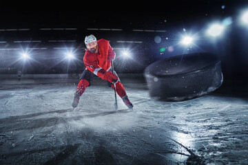 Ice hockey rink arena with professional player shooting the puck with hockey stick. Focus on 3D...