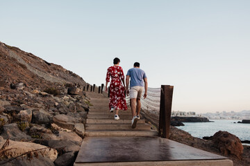 Couple walking up stairs on rocky Canary Islands coast