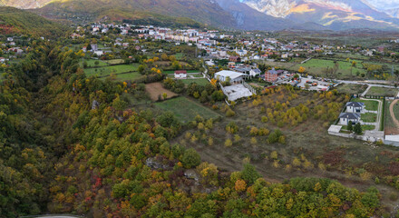 Autumn trees and farmland surround the outskirts of Bajram Curri beneath the dramatic Albanian Alps