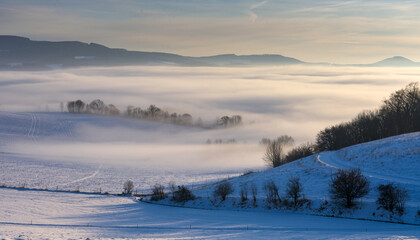Winter landscape with fog rolling over snow fields