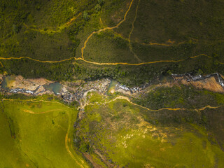 Aerial view of the river's silver thread winding through the emerald and ochre landscape, a tapestry woven by nature's hand, curiti, Santander, Colombia.