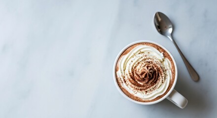 Hot chocolate in a white mug topped with whipped cream and cocoa powder, placed on a light marble surface, creating a cozy and inviting atmosphere for winter enjoyment