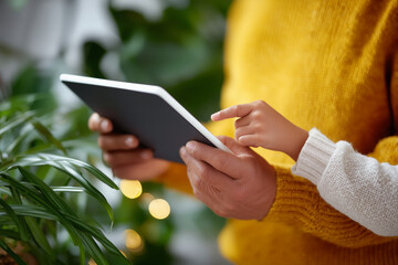 Parent and child hands using digital tablet