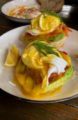 Gourmet grilled toast topped with fresh sliced avocado and classic Eggs Benedict with creamy hollandaise sauce.