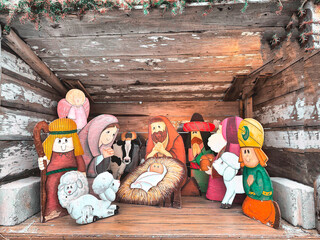 A nativity scene depicts the birth of Jesus, surrounded by Mary, Joseph, and various characters. The figures are brightly colored and cartoonish, giving a whimsical feel.