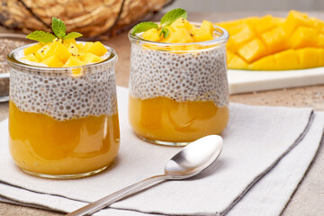 Homestyle mango chia puddings on linen cloth, Layered mango and chia custard served in rustic ambiance