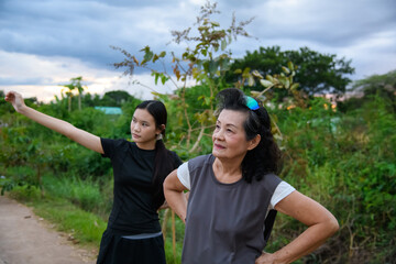 Grandma and granddaughter walk together in the park