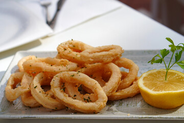 Traditional Spanish cuisine. Calamari with parsley and lemon in a typical tapas bar.