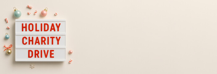 Holiday charity drive sign with festive decorations on a neutral background