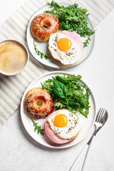 Healthy breakfast. Bagels with fried egg, ham and greens