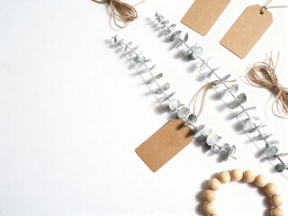Natural eucalyptus branches with tags and wooden beads on white background  